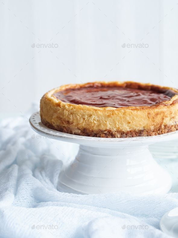 cheese cake with strawberry jam on top on a white cake stand Stock Photo by anal74